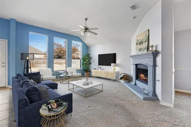 an empty room with windows fireplace and fans