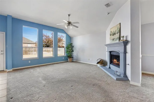 an empty room with a fireplace and potted plant