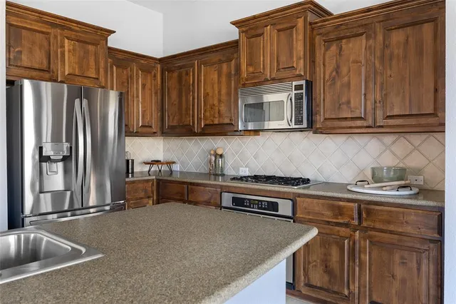 a kitchen with stainless steel appliances granite countertop a sink stove and cabinets