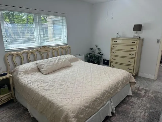a large bed sitting in a bedroom next to a window
