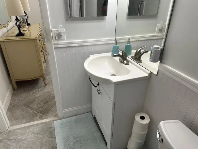 a bathroom with a sink a toilet and mirror