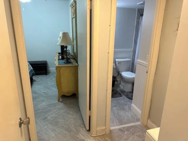 a view of a hallway with living room and a bathroom