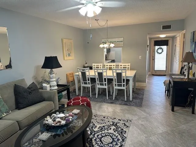 a living room with furniture a chandelier a rug and a window