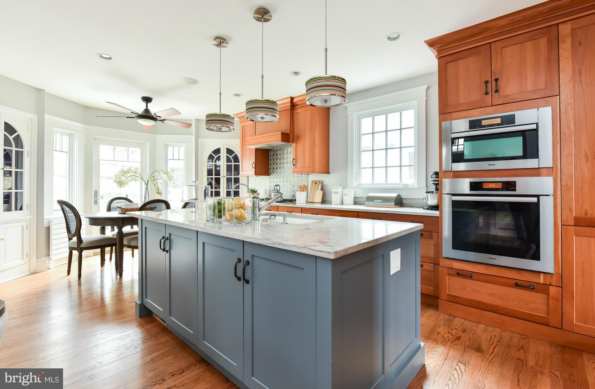 5517 Broad Branch Road Northwest Washington, DC 20015 - Photo 13 of 25 a open kitchen with stainless steel appliances granite countertop a stove top oven a sink dishwasher a dining table and chairs with wooden floor