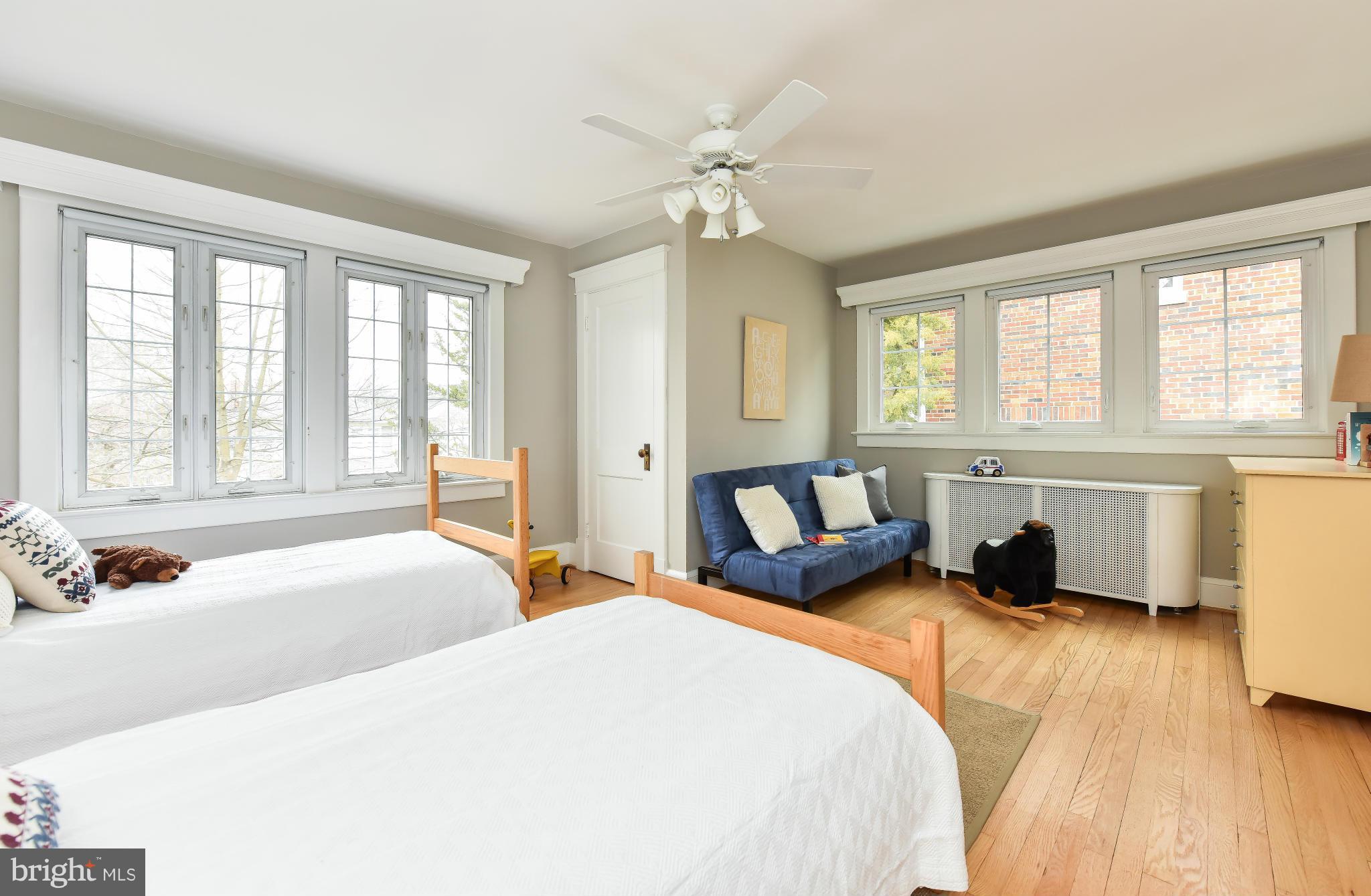 5517 Broad Branch Road Northwest Washington, DC 20015 - Photo 18 of 25 a spacious bedroom with a large bed and a chandelier