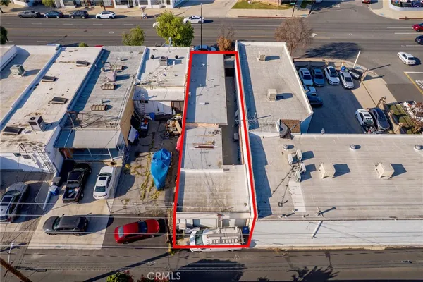 an aerial view of a building with parked cars