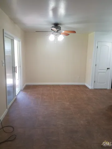 en empty room with windows and chandelier fan