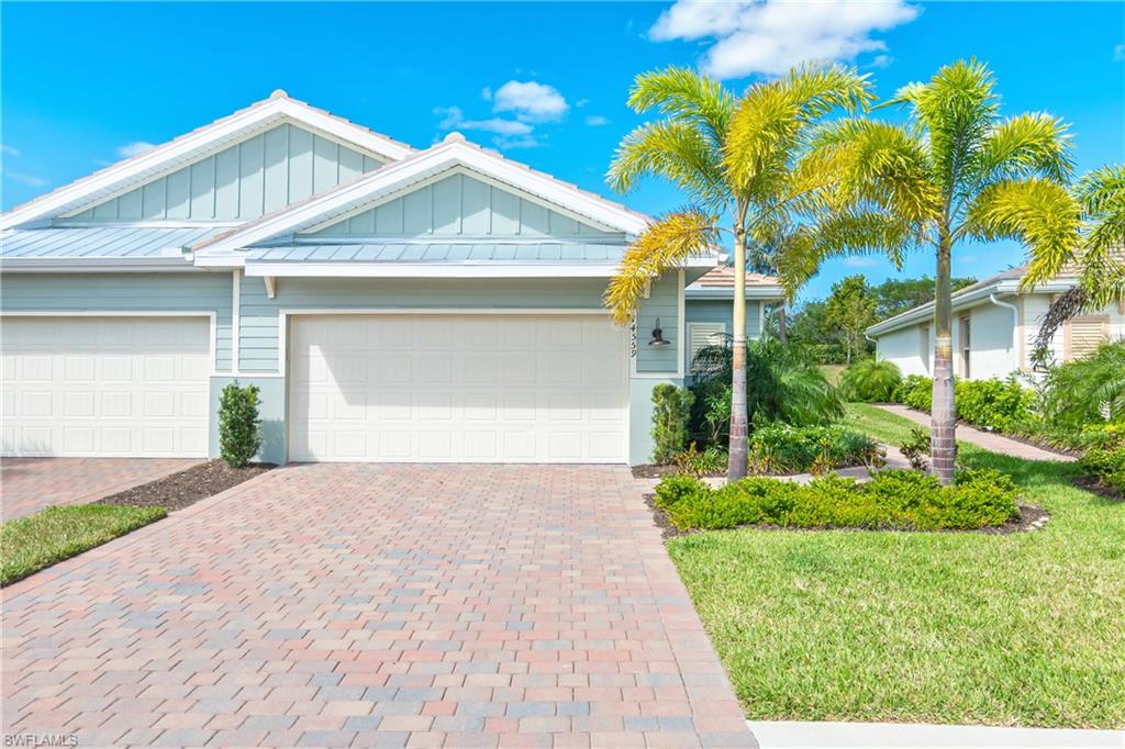 14559 Edgewater Circle Naples, FL 34114 - Photo 23 of 49 a front view of a house with a yard and potted plants