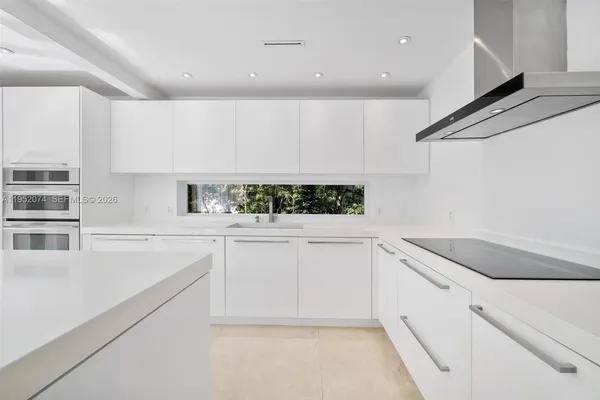a kitchen with granite countertop white cabinets and white appliances