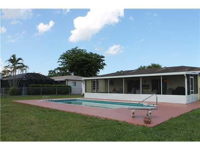 22369 Boulder Street Boca Raton, FL 33428 - Photo 3 of 15 a swimming pool with outdoor seating and yard
