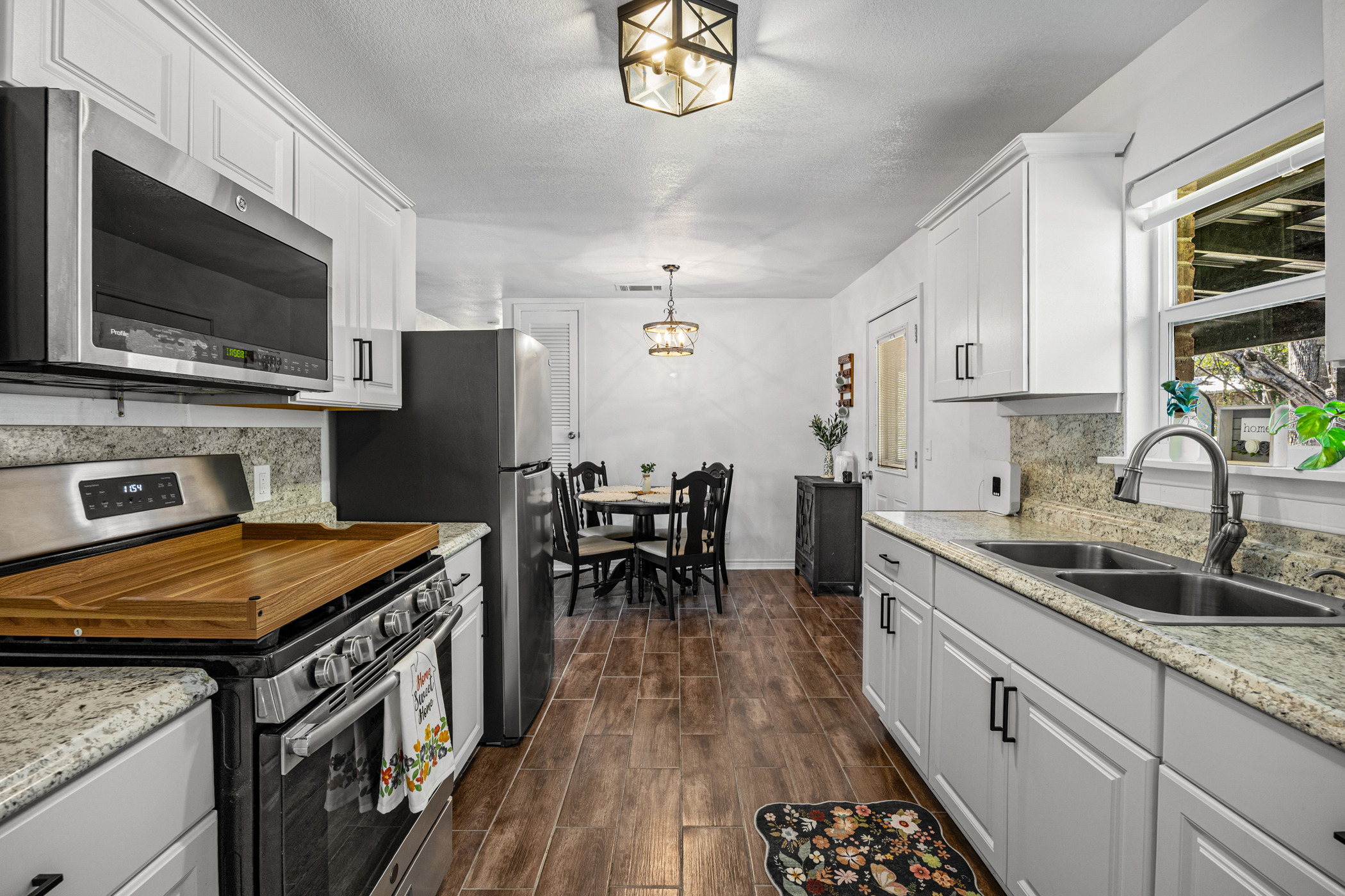 6010 Waycross Drive Austin, TX 78745 - Photo 11 of 22 a kitchen with stainless steel appliances a kitchen island hardwood floor sink stove dining table and chairs