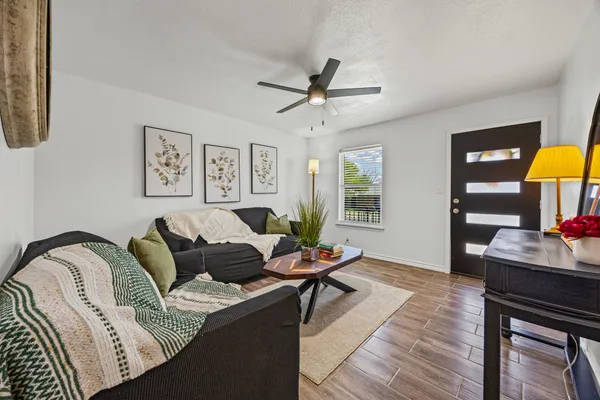 a living room with furniture and a wooden floor