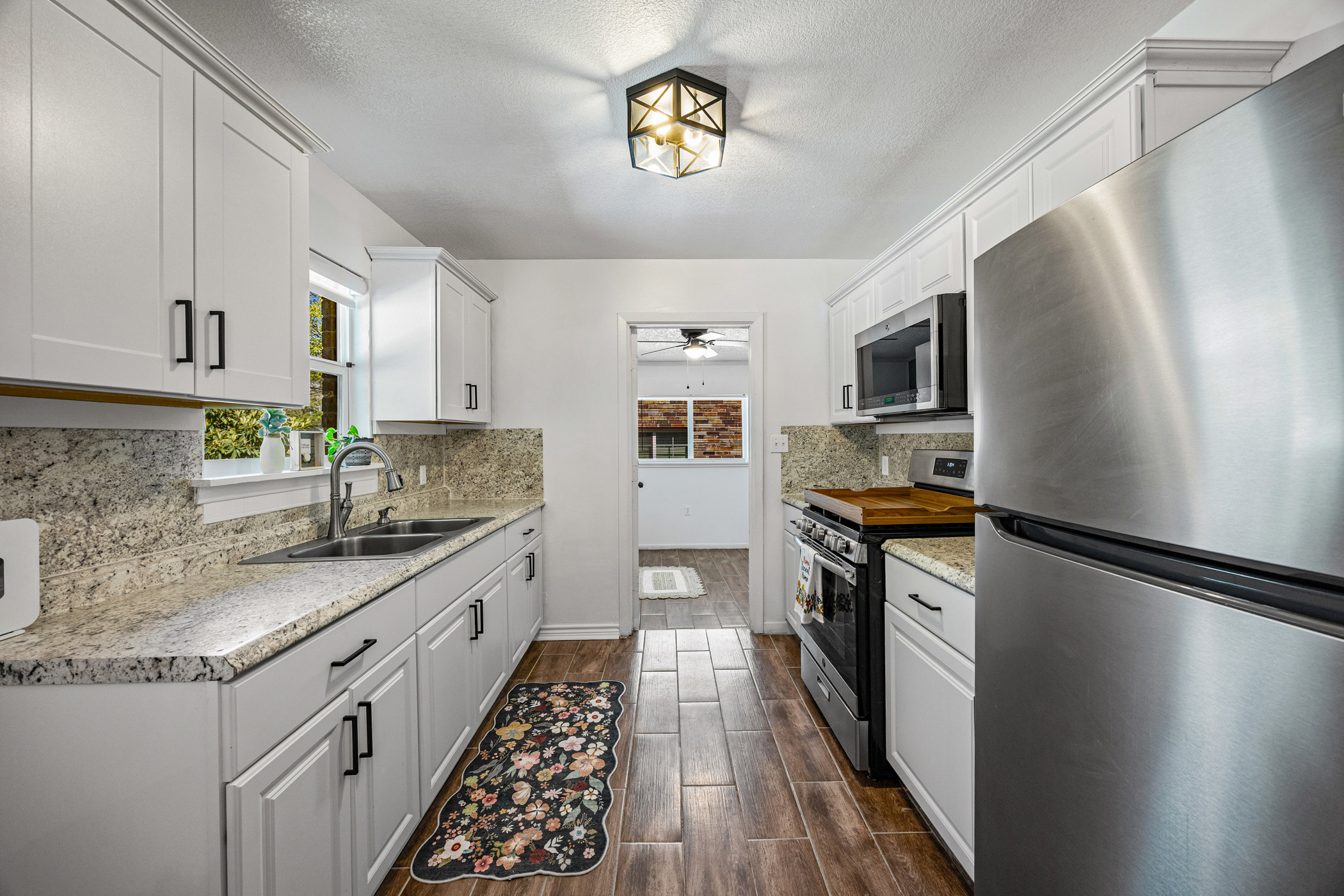 6010 Waycross Drive Austin, TX 78745 - Photo 10 of 22 a kitchen with granite countertop stainless steel appliances a sink stove top oven and wooden floor
