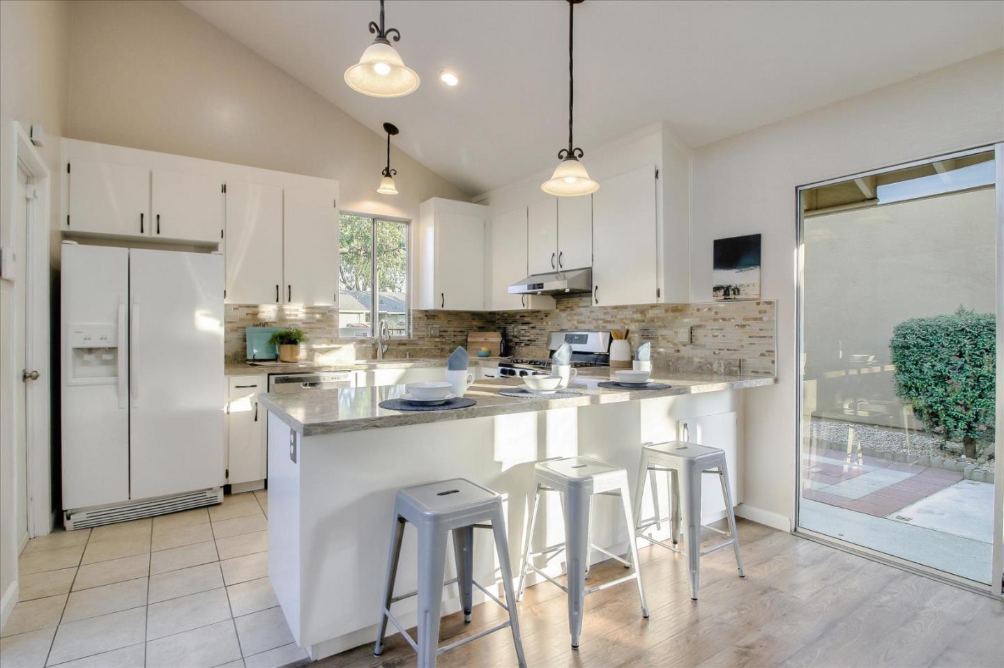 5278 Garrison Circle San Jose, CA 95123 - Photo 9 of 31 a kitchen with stainless steel appliances granite countertop a refrigerator a sink dishwasher a stove and white cabinets with wooden floor