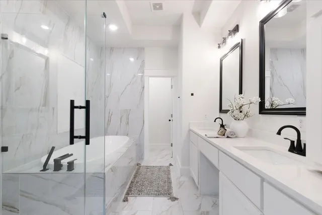 a bathroom with a double vanity sink a mirror and a bathtub