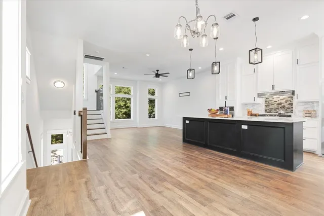 a living room with kitchen island furniture and a chandelier