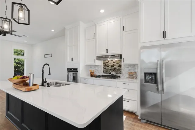 a kitchen with stainless steel appliances a refrigerator sink and cabinets