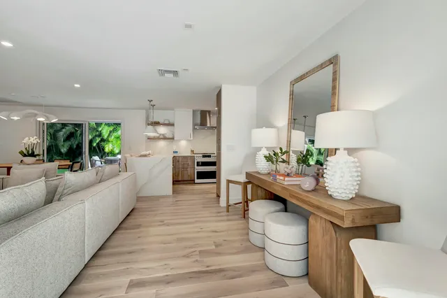 a kitchen with stainless steel appliances a white table chairs and a refrigerator