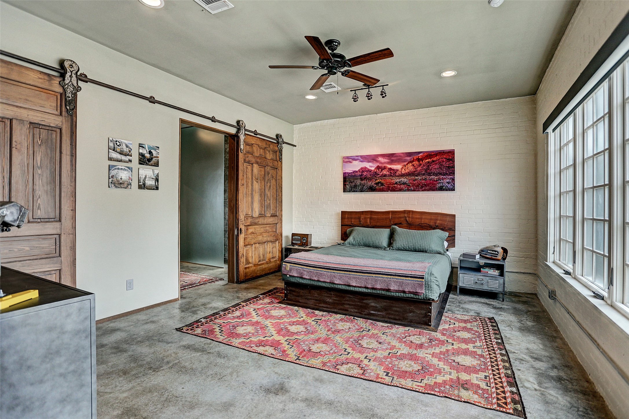 808 Coronado Street Houston, TX 77009 - Photo 35 of 50 Unit 2, primary bedroom with exposed brick, double barn doors, and direct access to the walk-in closet and en suite bath.