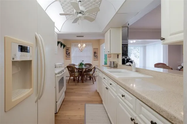 a kitchen with white cabinets and sink