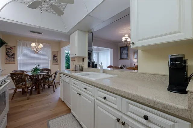 a kitchen with stainless steel appliances granite countertop a sink a stove and white cabinets