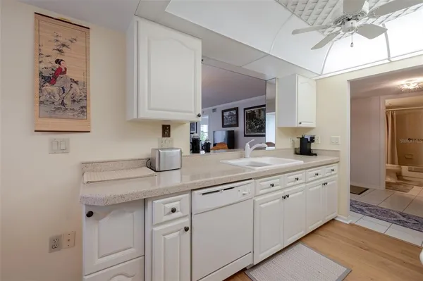 a kitchen with white cabinets and sink