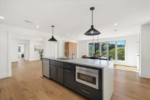 a kitchen with stainless steel appliances a stove and a wooden floor