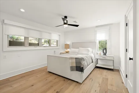a white bed sitting in a room next to a window