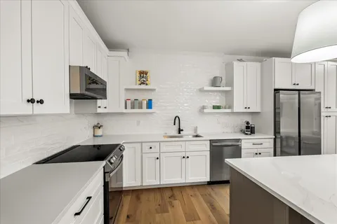 a kitchen that has a sink a stove and a refrigerator