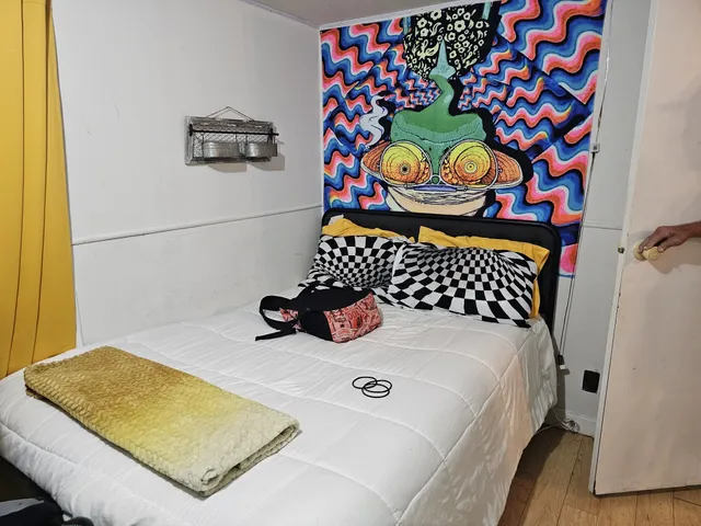 a bedroom with a bed and wall painting on the wall