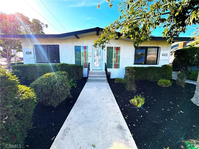 a front view of a house with a garden