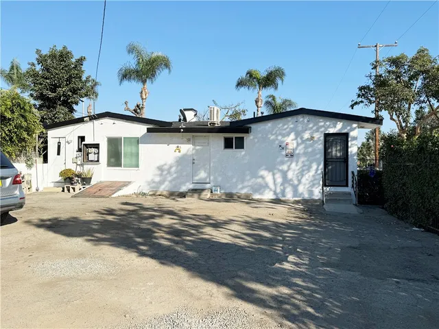 a front view of a house with a yard garden and outdoor seating