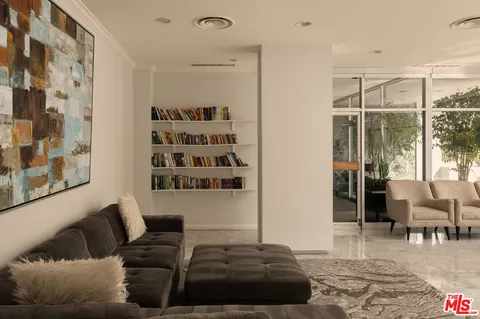 a living room with furniture a rug and white walls
