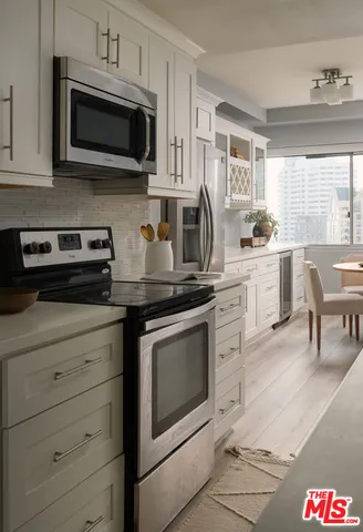 a kitchen with stainless steel appliances granite countertop white cabinets and stove