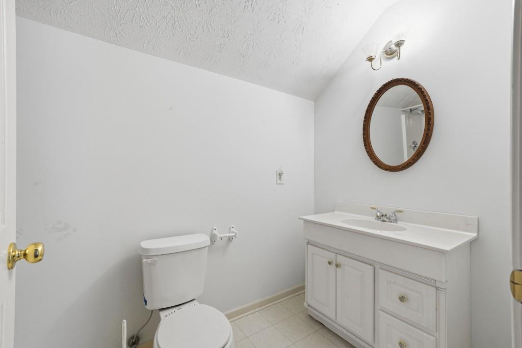 176 Big Oak Tree Road Northwest Adairsville, GA 30103 - Photo 37 of 77 a bathroom with a toilet a sink a mirror and vanity