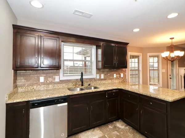 a kitchen with granite countertop a sink and cabinets