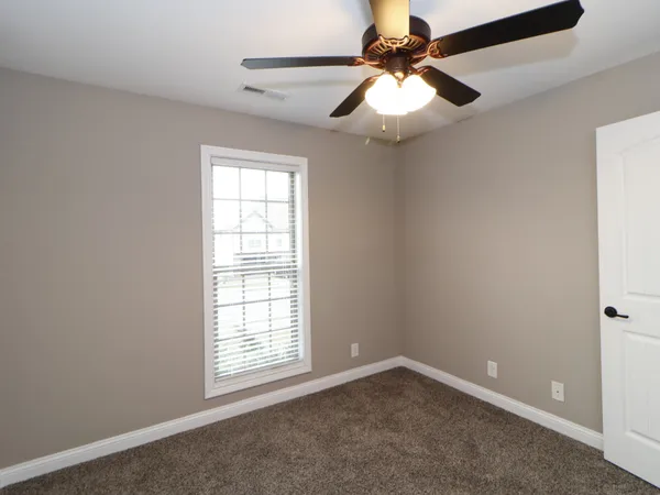 an empty room with fan and windows