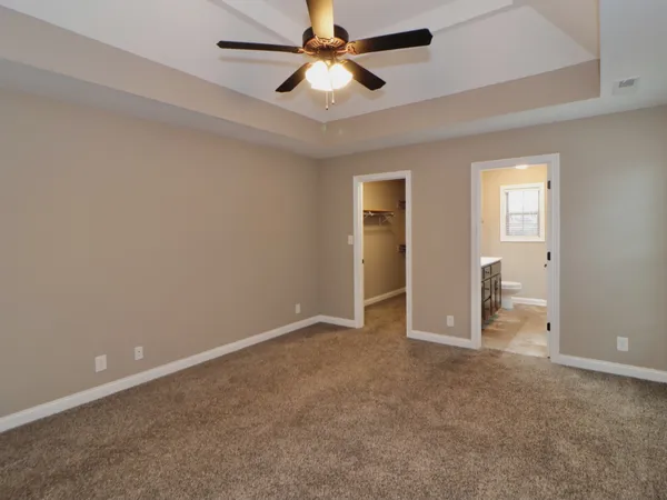 an empty room with closet and a ceiling fan