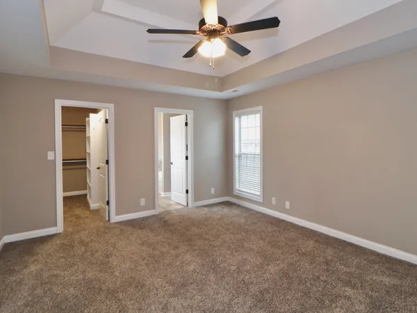 an empty room with closet and a ceiling fan