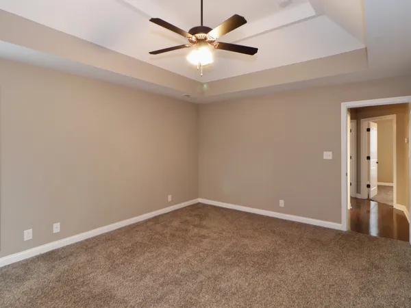an empty room with closet and a ceiling fan