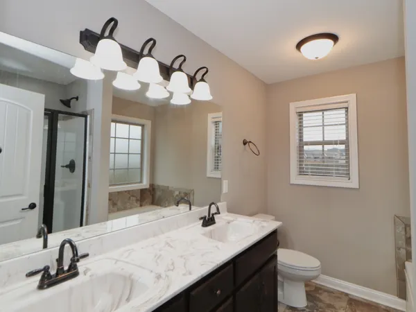 a bathroom with a granite countertop sink a toilet and a mirror