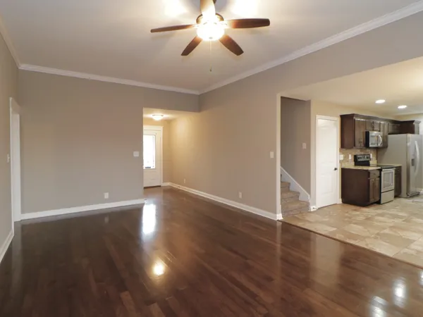 a view of a kitchen with a stove wooden floor a ceiling fan and kitchen view