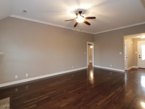 a view of an empty room with wooden floor