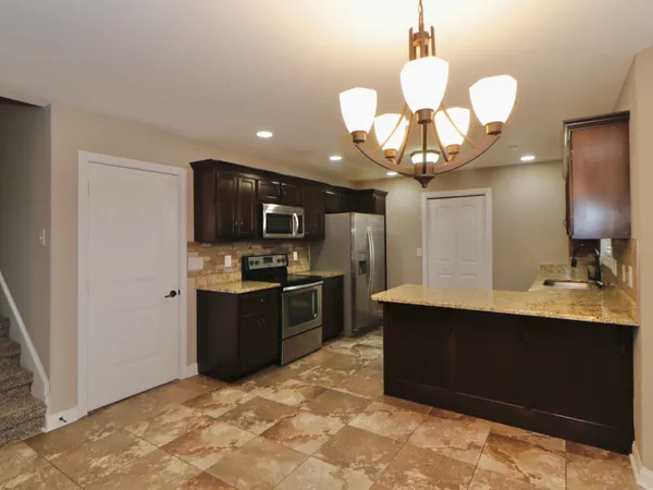 a kitchen with stainless steel appliances granite countertop a sink dishwasher stove and refrigerator