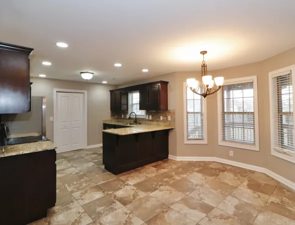 a large kitchen with a refrigerator a sink dishwasher with a dining table and chairs