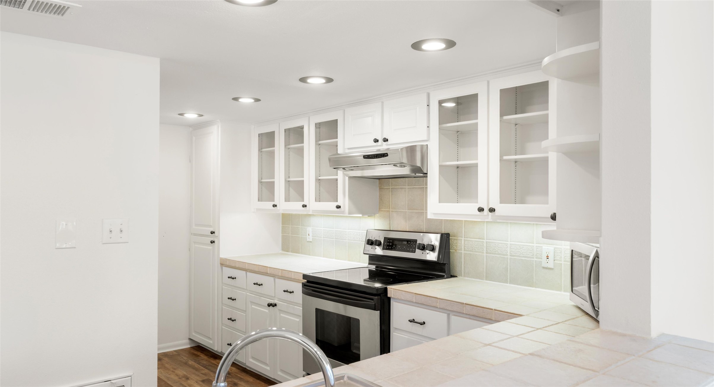2918 Ranch Road 620 North, Unit C122 Austin, TX 78734 - Photo 13 of 36 Well-appointed kitchen featuring white cabinetry, stainless steel appliances, recessed lighting, and a tiled backsplash