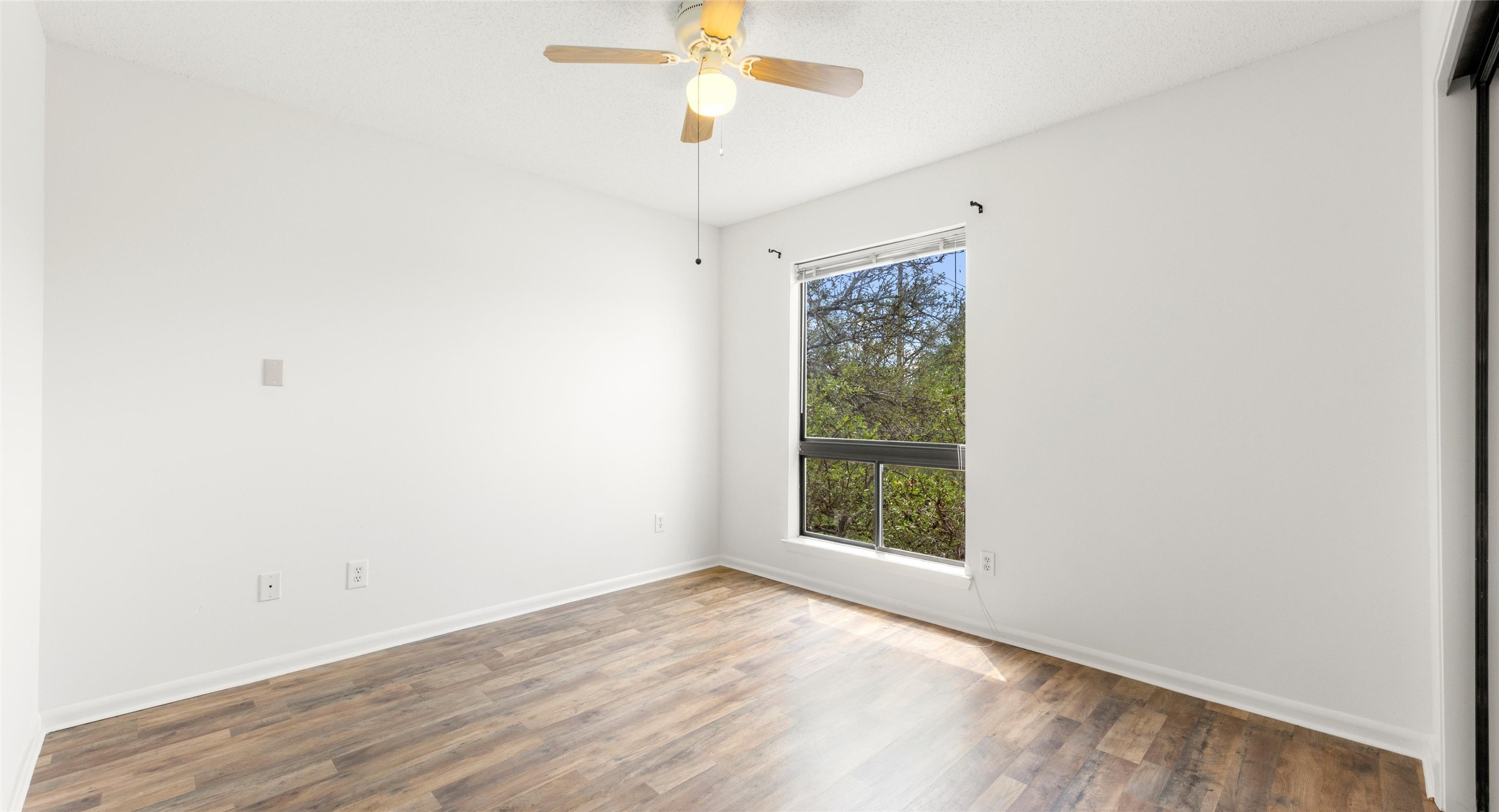 2918 Ranch Road 620 North, Unit C122 Austin, TX 78734 - Photo 14 of 36 This room features wood-style flooring, a window offering a view of greenery, and a ceiling fan
