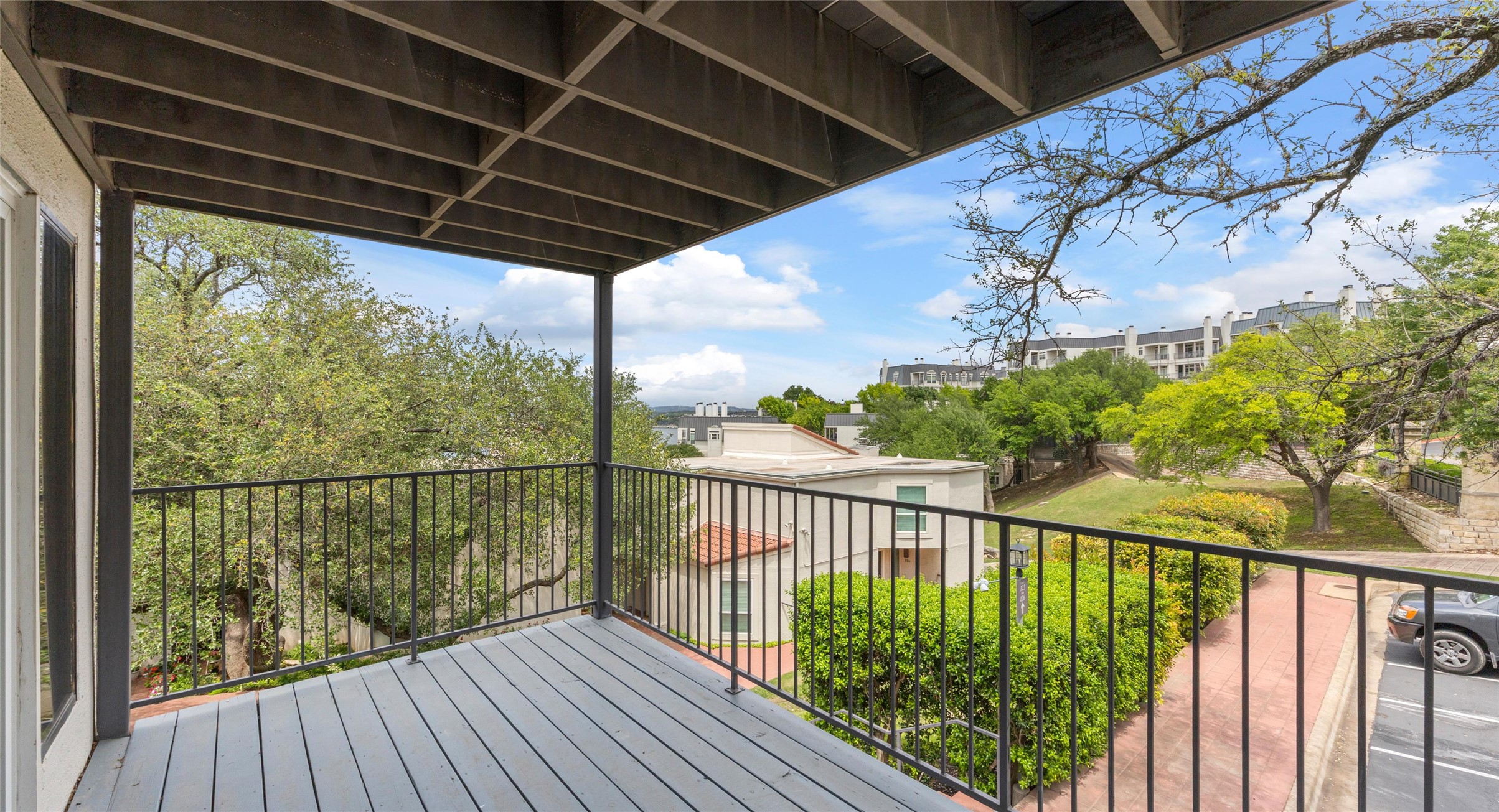 2918 Ranch Road 620 North, Unit C122 Austin, TX 78734 - Photo 21 of 36 Balcony with a black metal railing and a view of the surrounding trees and buildings