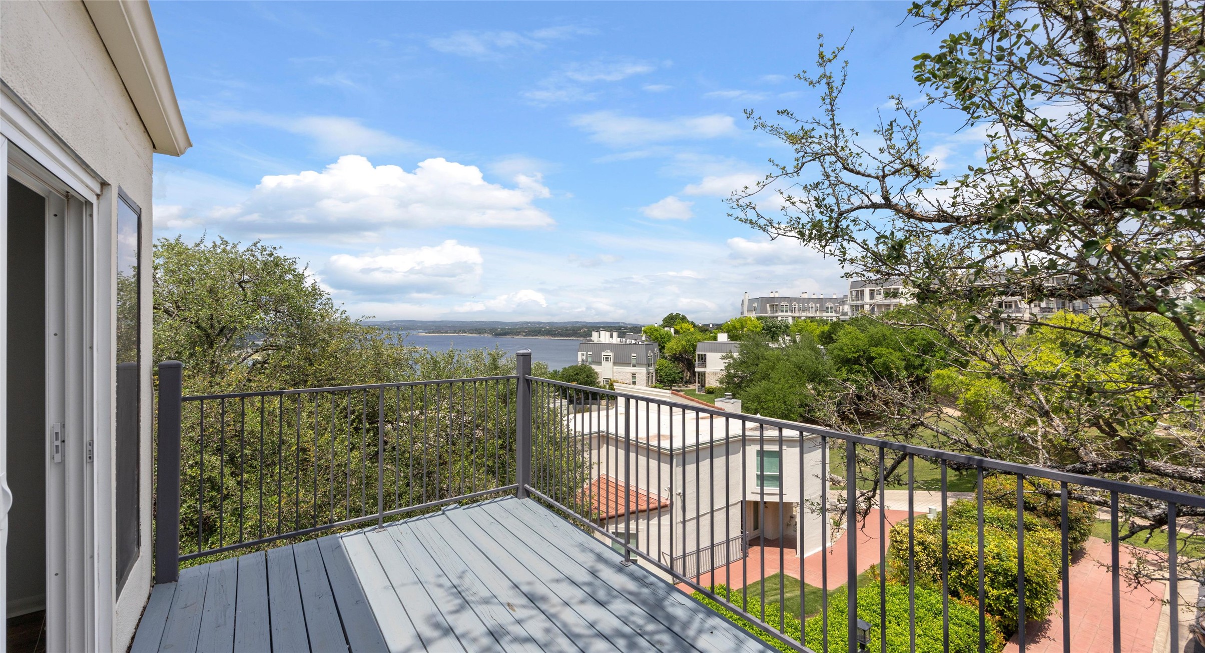 2918 Ranch Road 620 North, Unit C122 Austin, TX 78734 - Photo 23 of 36 The property features an outdoor deck with a metal railing and views of a body of water, distant buildings, and surrounding trees