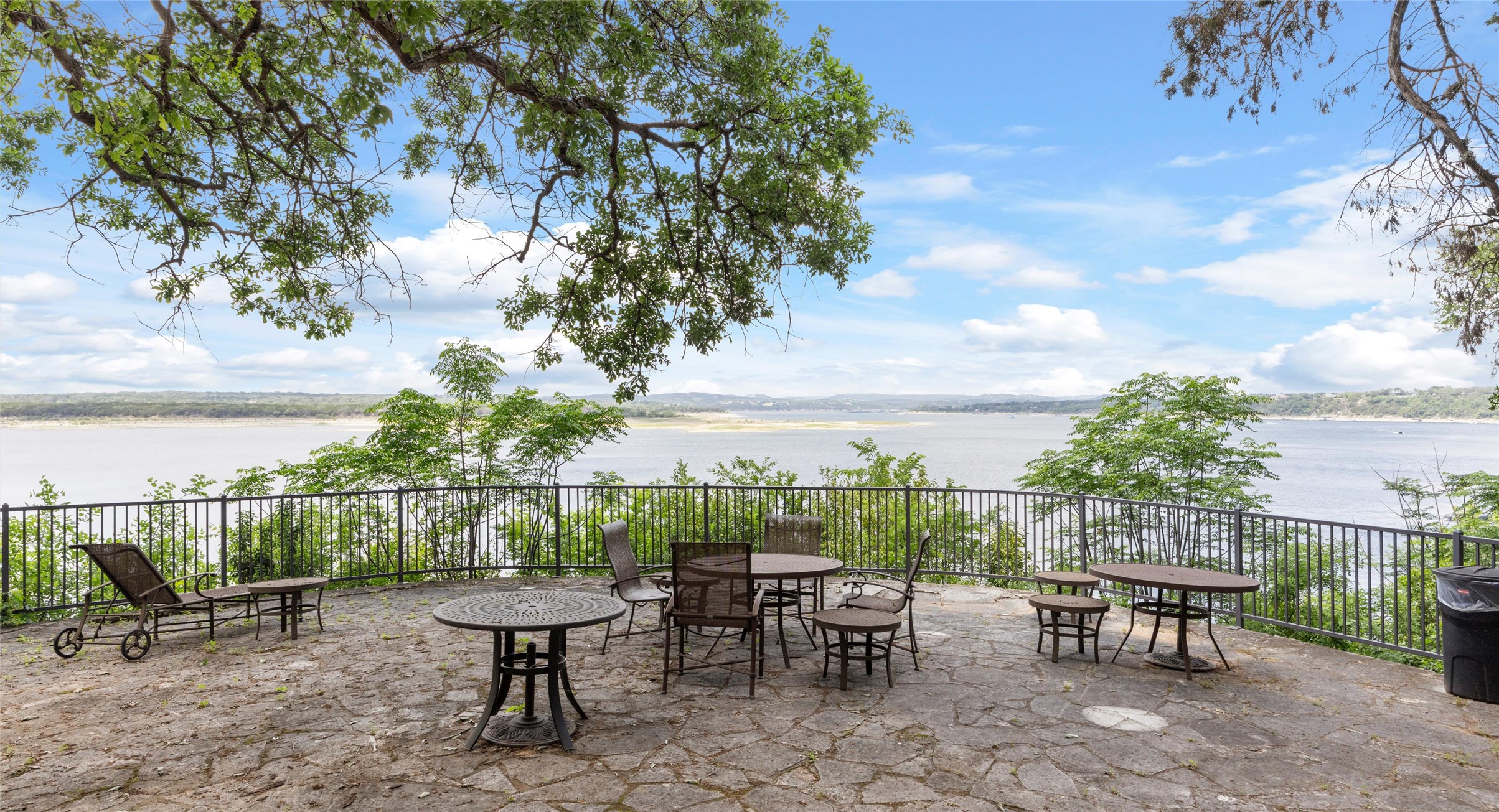 2918 Ranch Road 620 North, Unit C122 Austin, TX 78734 - Photo 29 of 36 The property features an expansive stone patio with a scenic water view, encompassed by mature trees and a protective railing